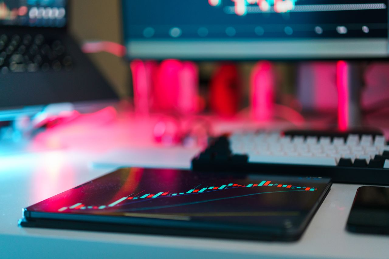 who-we-are Configuration de trading high-tech avec graphiques sur des écrans de tablette et d’ordinateur, illustrant l’analyse de données et les tendances financières.